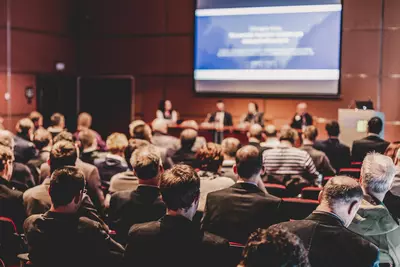 Vorlesungssaal voller Menschen während einer Podiumsdiskussion